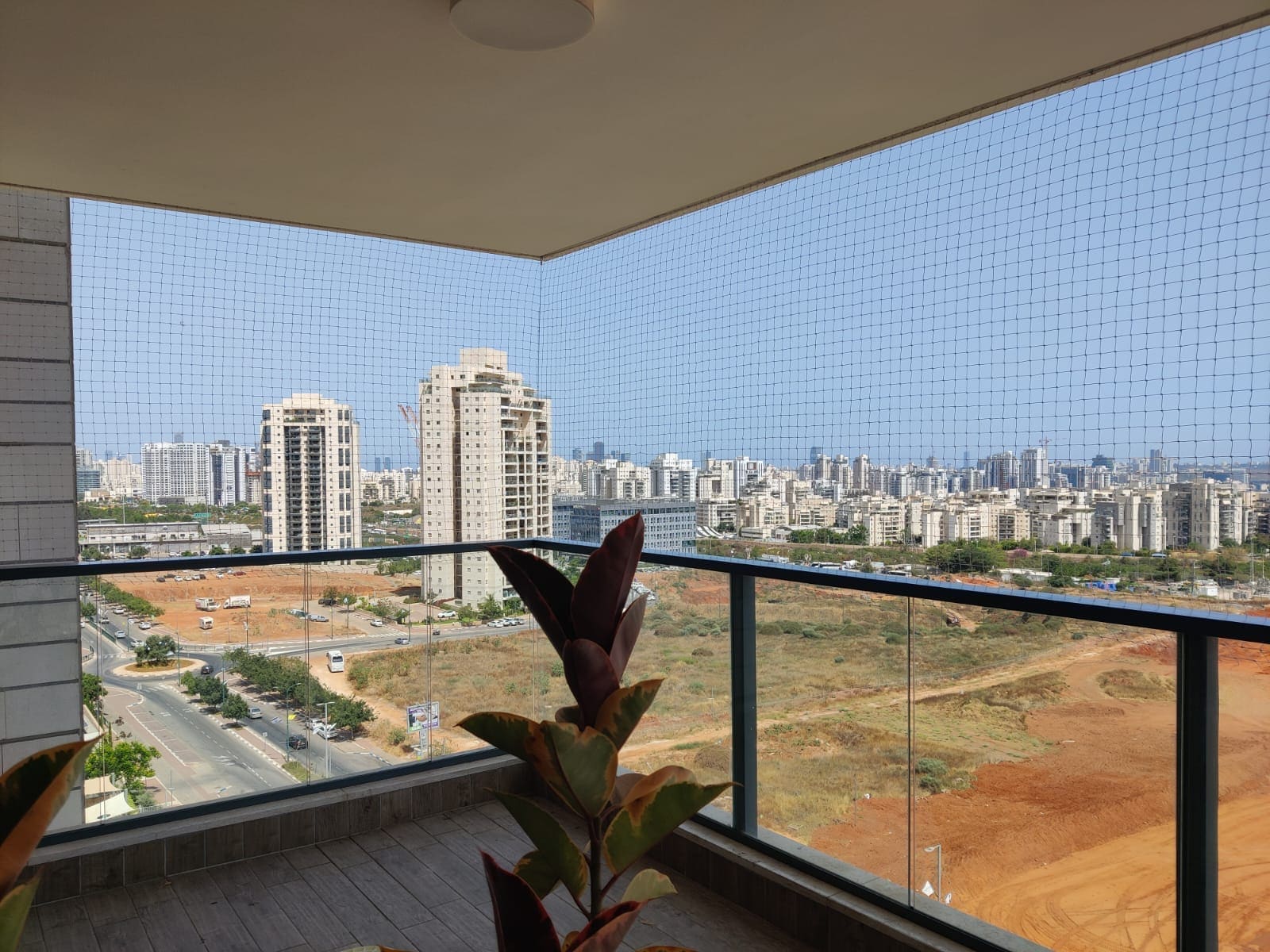 רשת יונים על מרפסת עם מעקה זכוכית